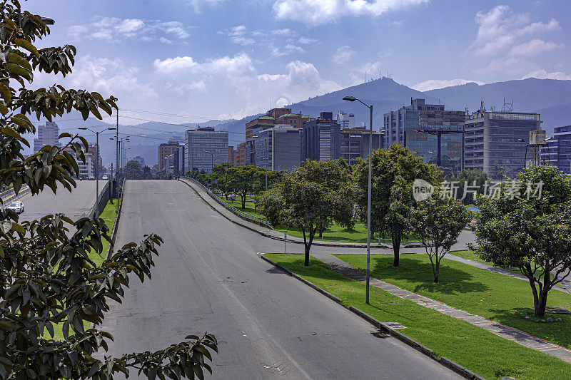 在哥伦比亚首都波哥大的La Castellana地区的自动驾驶塔上Calle 100桥的高角度视图。这里通常挤满了重型车辆，但由于冠状病毒封锁，这里被遗弃了